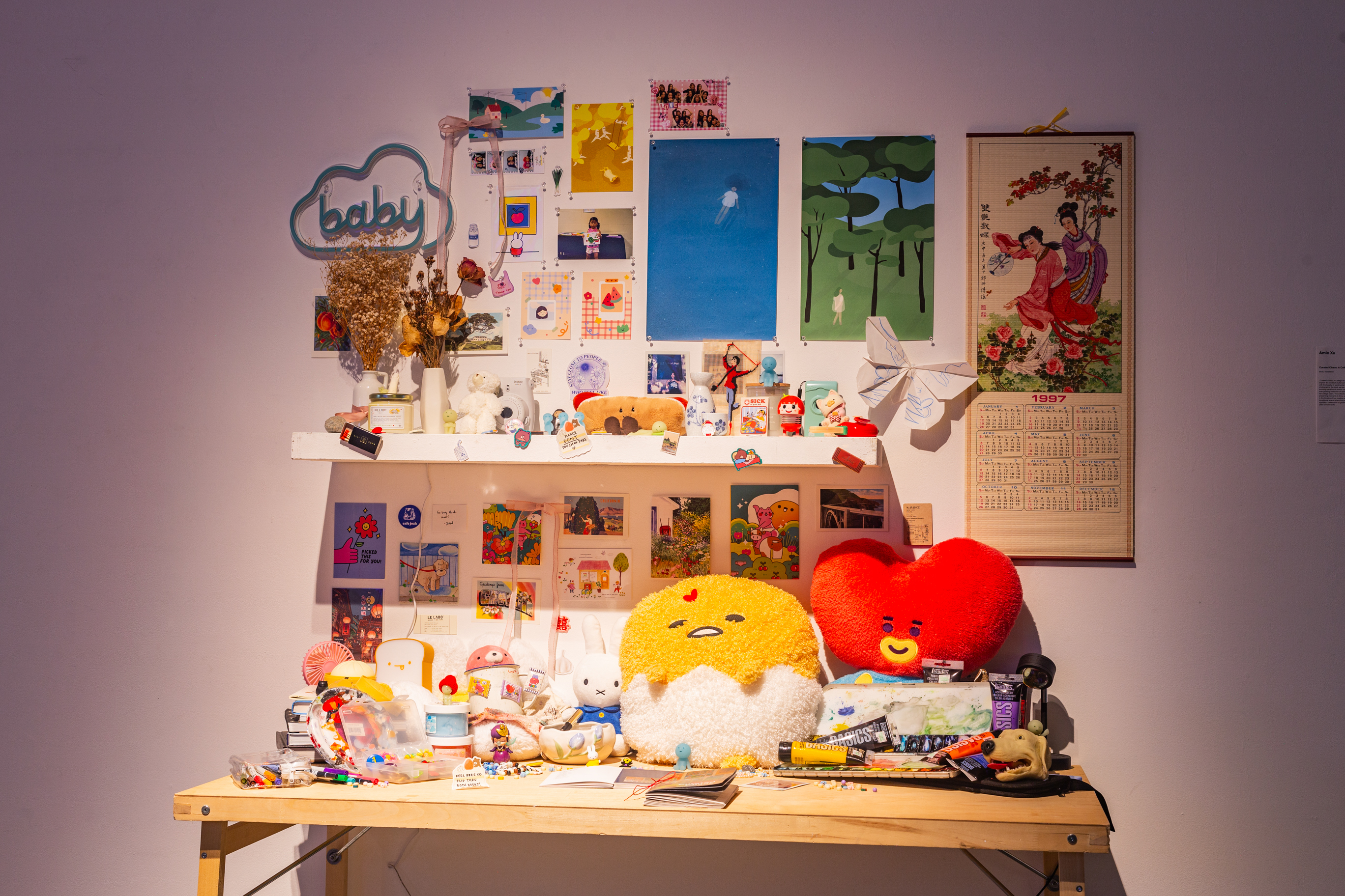 A wooden desk overly decorared with various plushies, collectibles, and printed photos.